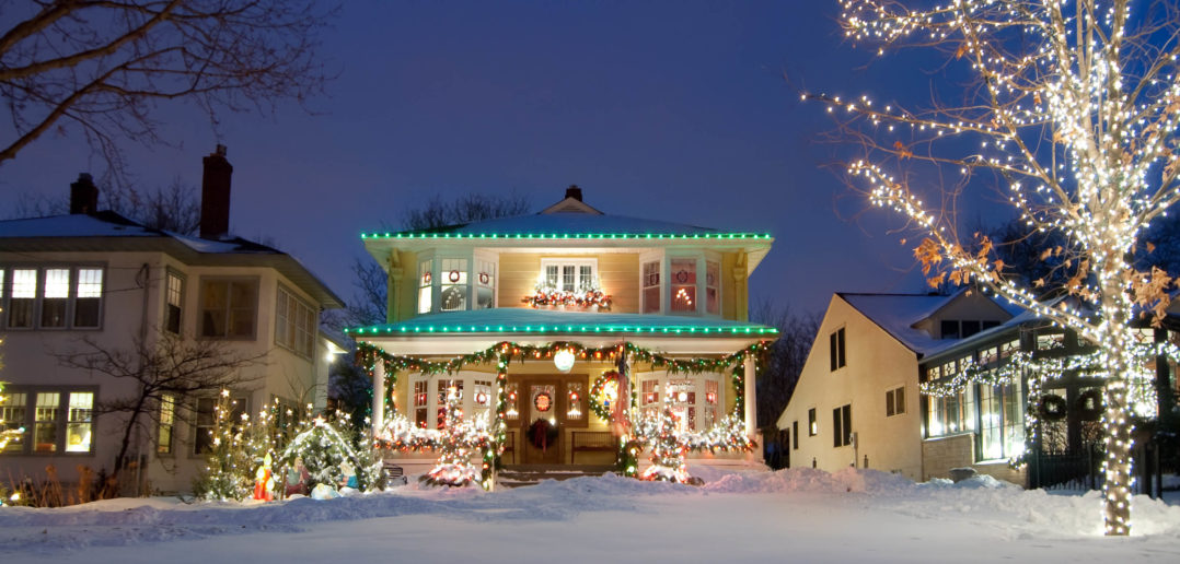 House with seasonal lighting decorated with festive items and bright led strands in the snow.