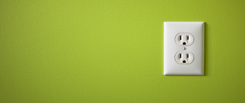 Green wall with white standard electrical socket